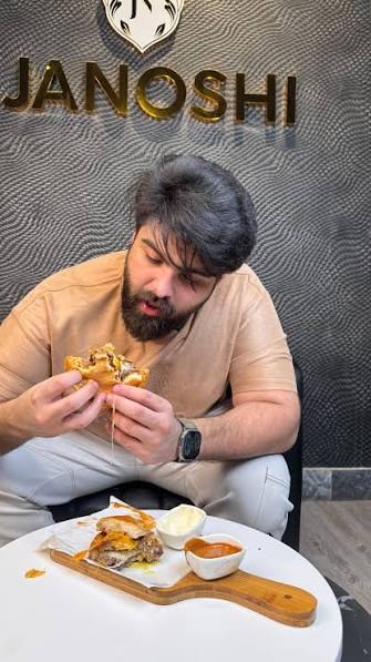 Guest biting into a loaded Janoshi burger